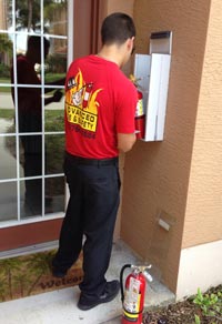 One of our trained professionals installing a fire extinguisher
